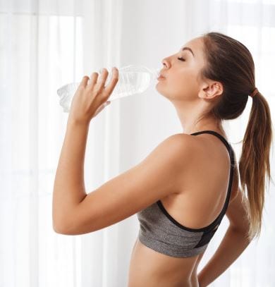 mujer deportista bebiendo de botella de agua